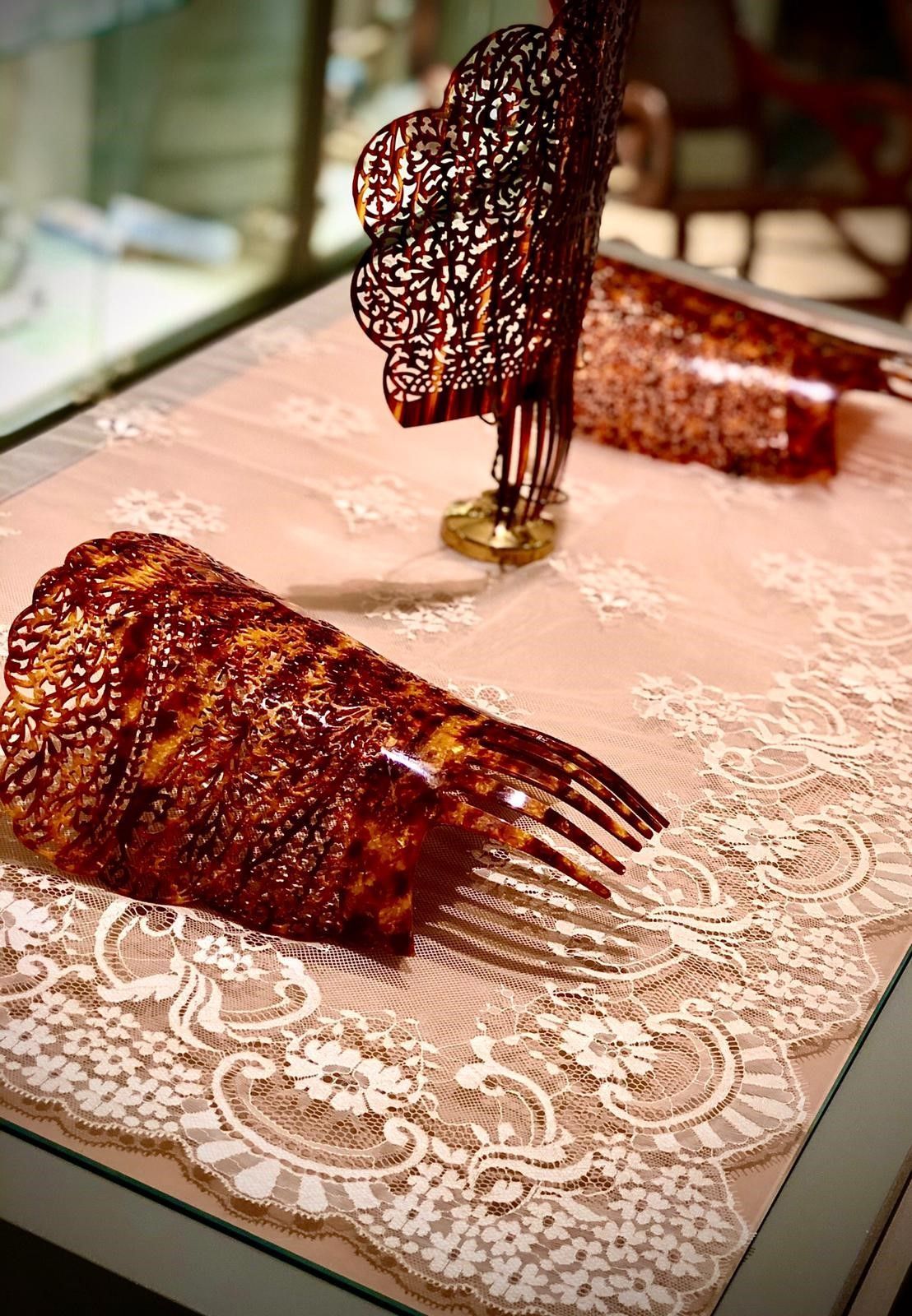 Un par de peines colocados encima de un mantel de encaje.