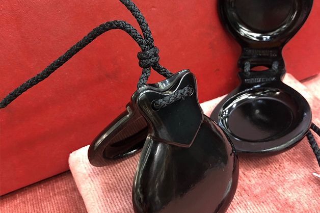 Un par de castañuelas negras sobre un paño rojo.