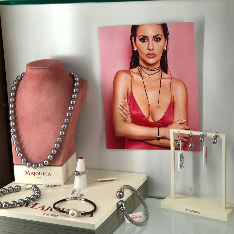 Una foto de una mujer está detrás de una exhibición de joyas.