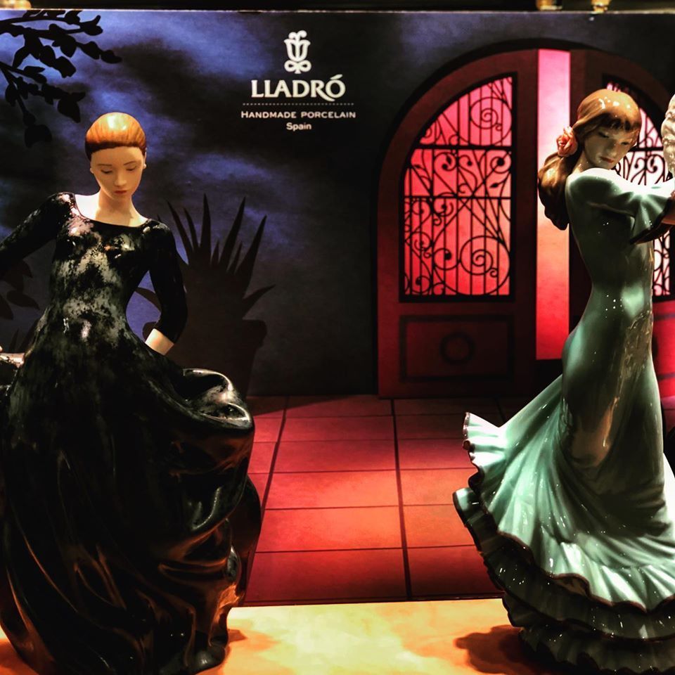 Dos figuras de porcelana están delante de un cartel que dice Lladró.