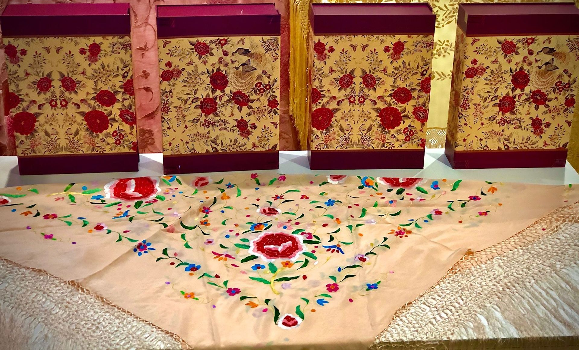 Una mesa con cajas y un mantel con flores.