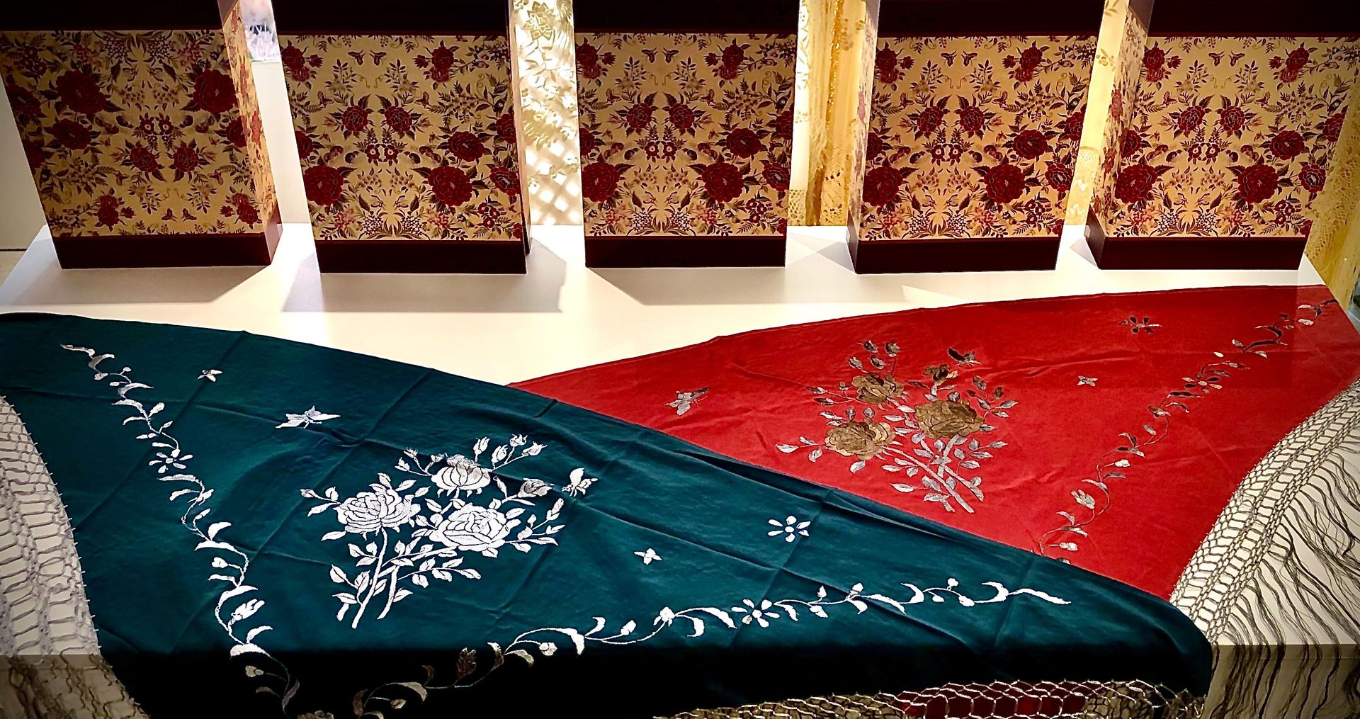 Una alfombra verde y roja están sobre una mesa en una habitación.
