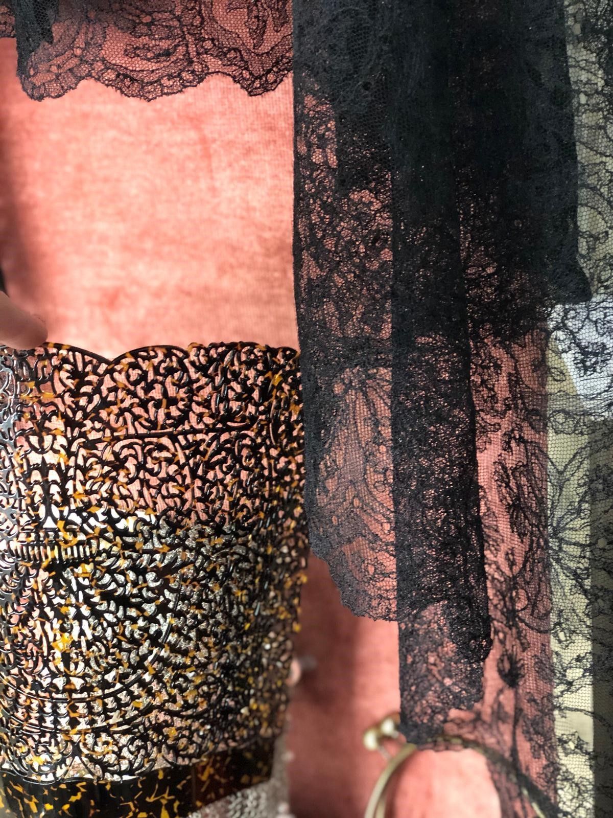 Un primer plano de una persona que lleva un top de encaje negro.