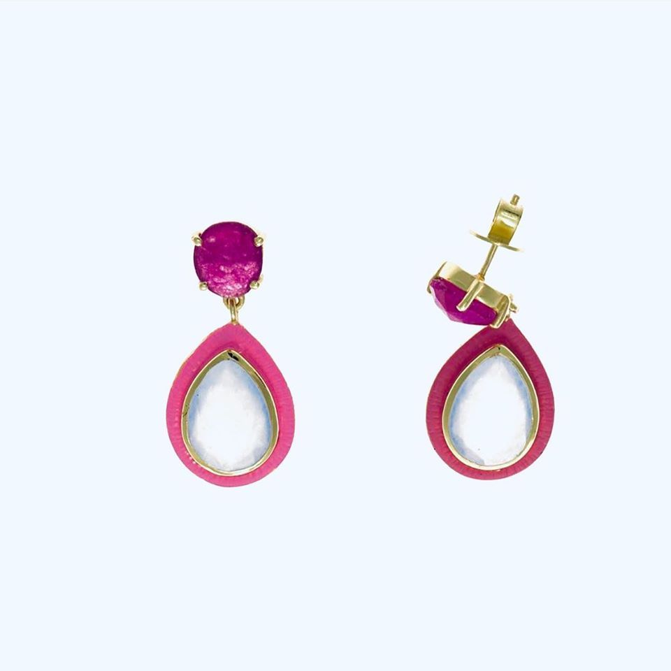 Un par de pendientes rosas y blancos sobre un fondo blanco.