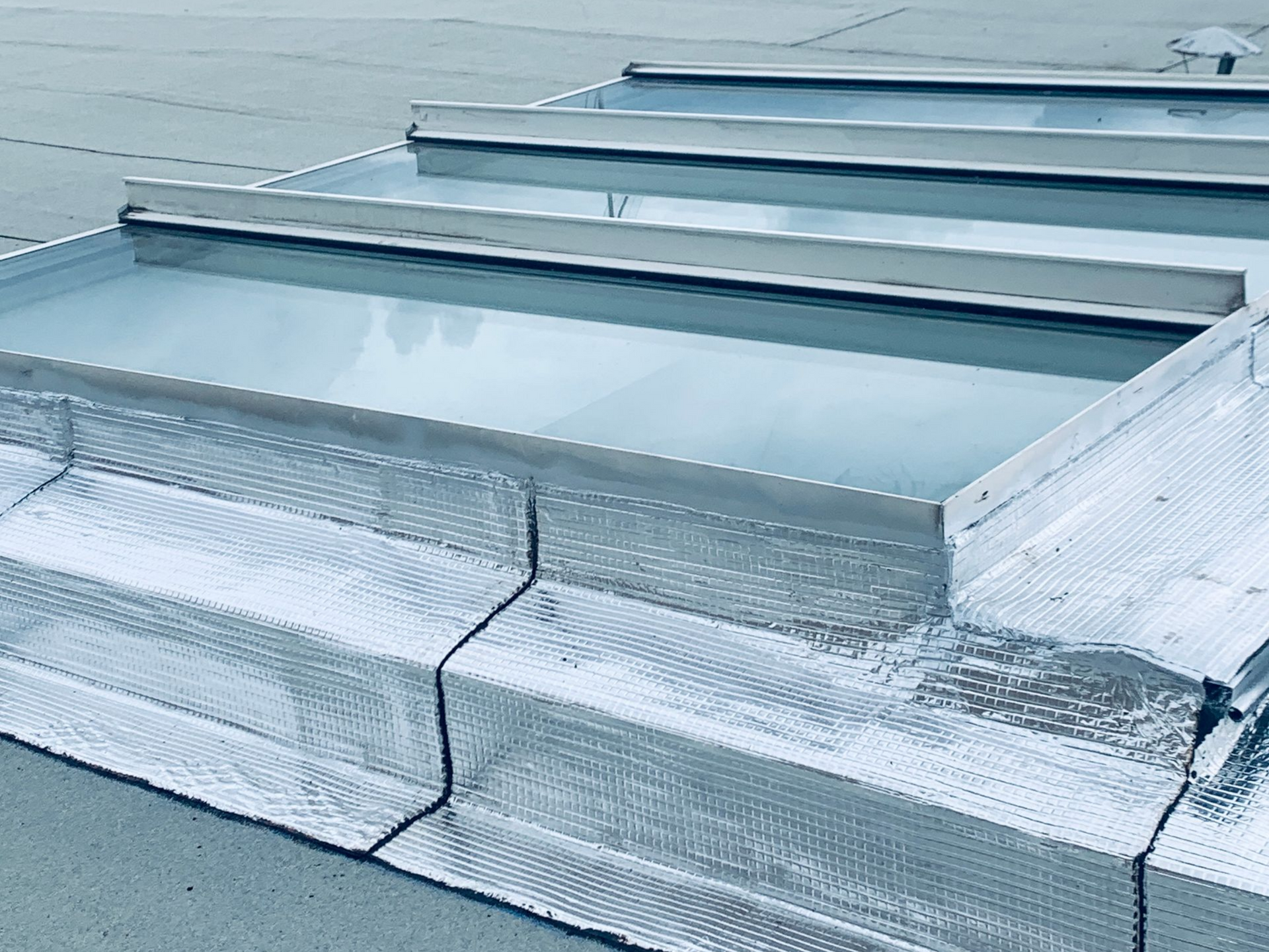 Puits de lumière sur un toit plat, détails de solins métalliques.