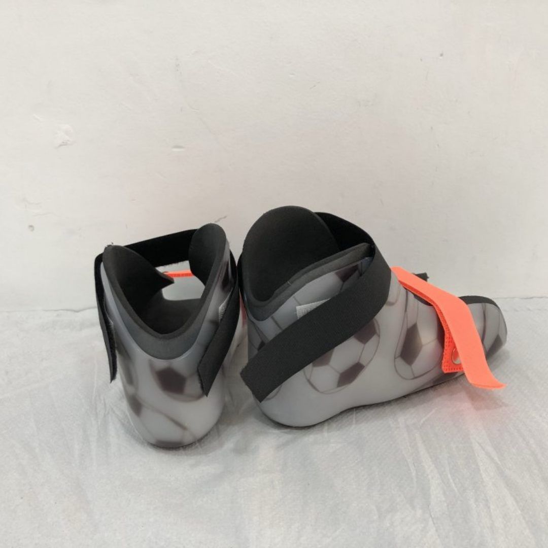 Un par de zapatos grises y negros con cordones naranjas.