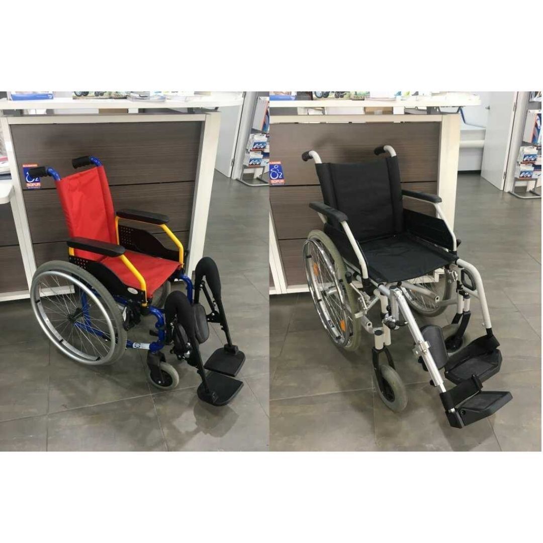 Una silla de ruedas roja y otra negra están sentadas una al lado de la otra en una tienda.