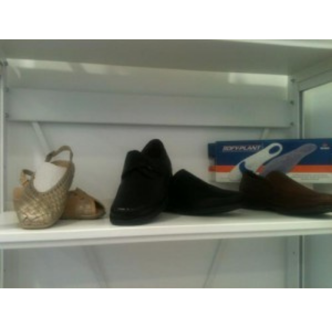 Un par de zapatos se encuentra en un estante junto a otro par de zapatos.
