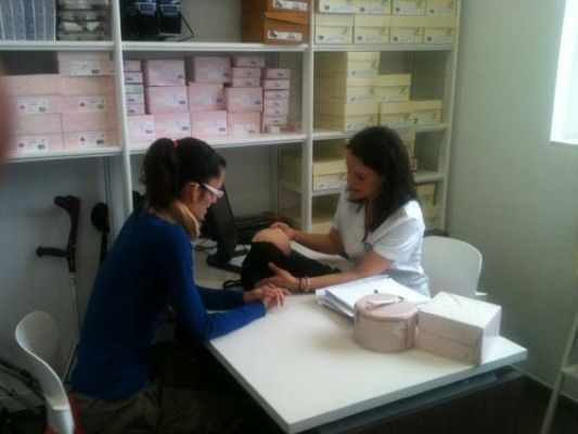 Dos mujeres están sentadas en una mesa hablando entre sí.