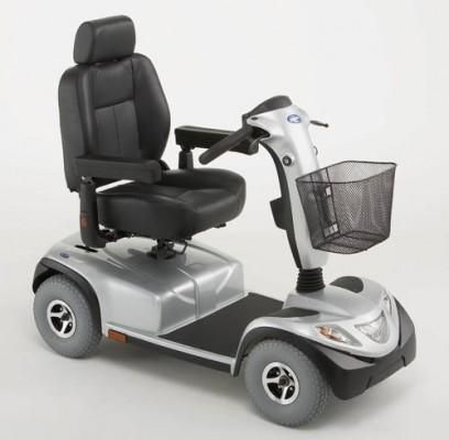 Un scooter de movilidad plateado con asiento y cesta negros.