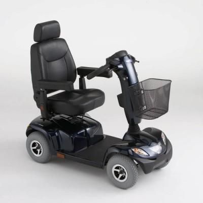 Un scooter de movilidad negro con una canasta en la parte delantera está sentado sobre una superficie blanca.