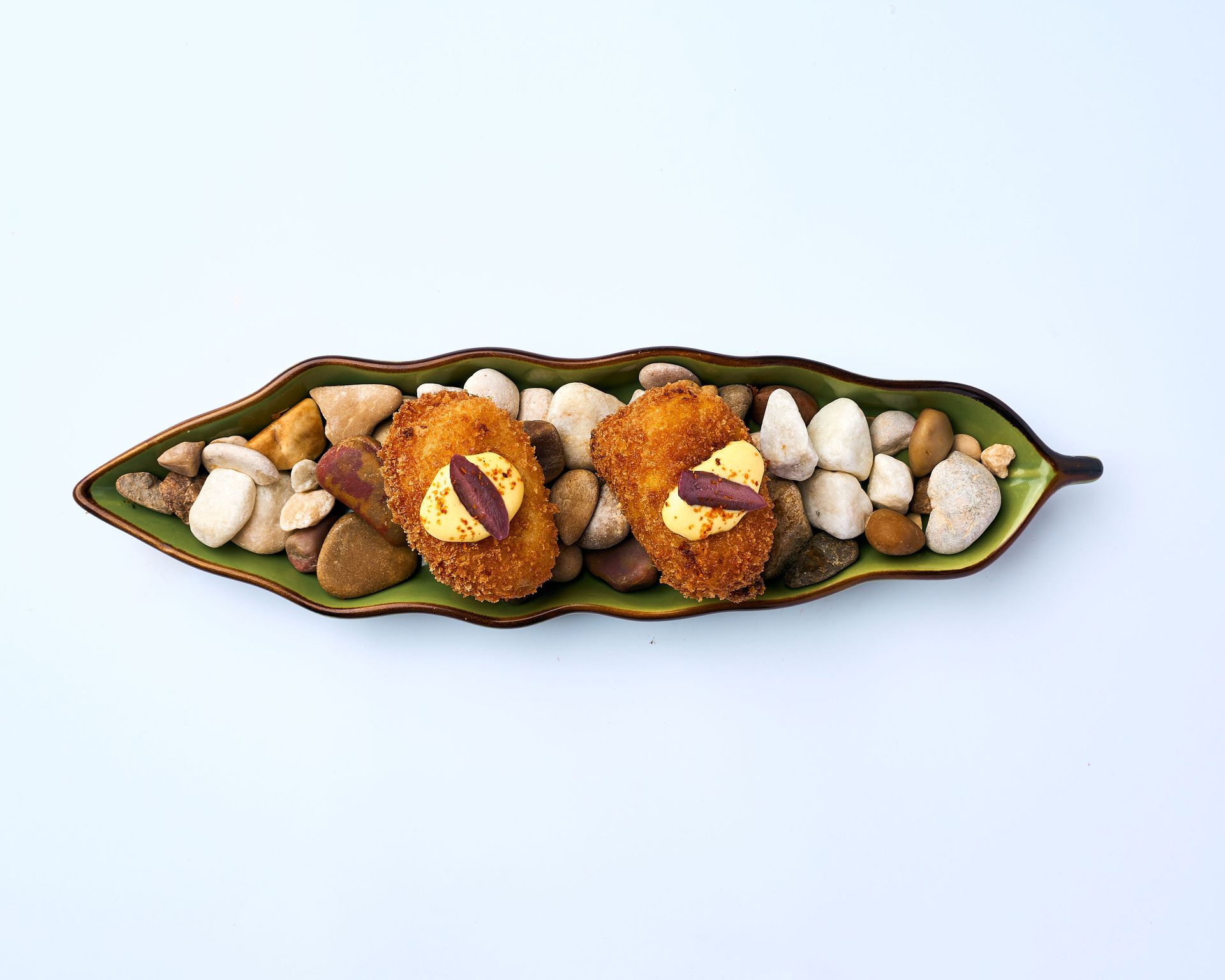 Una bandeja de madera llena de arroz y camarones sobre una mesa.