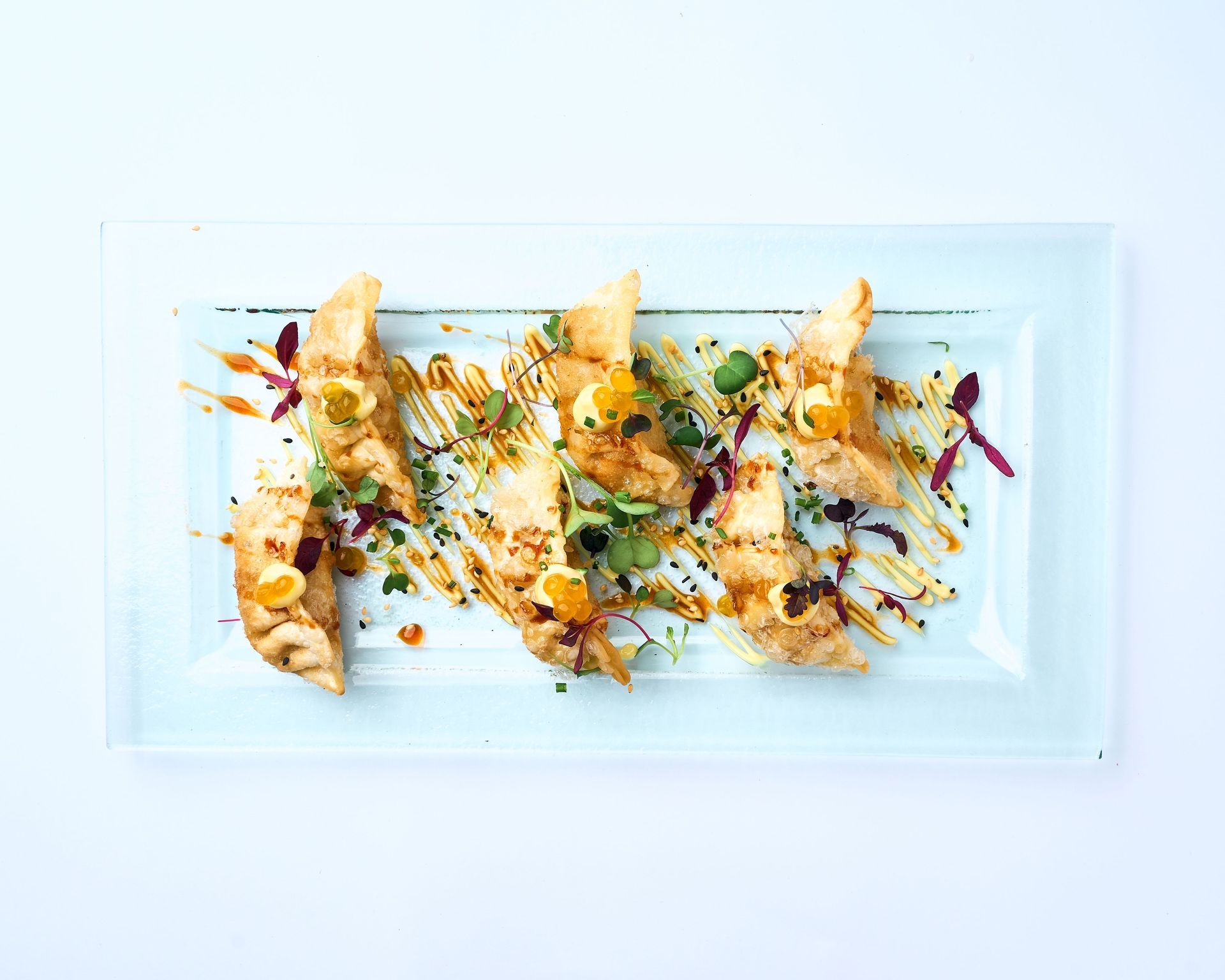 Un plato negro cubierto con albóndigas y verduras sobre una mesa.
