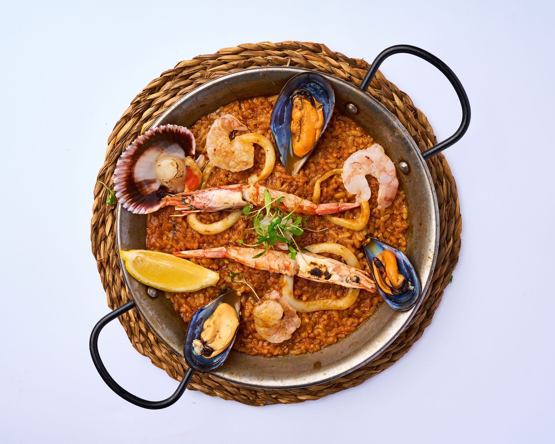 Una bandeja de madera llena de arroz y camarones sobre una mesa.