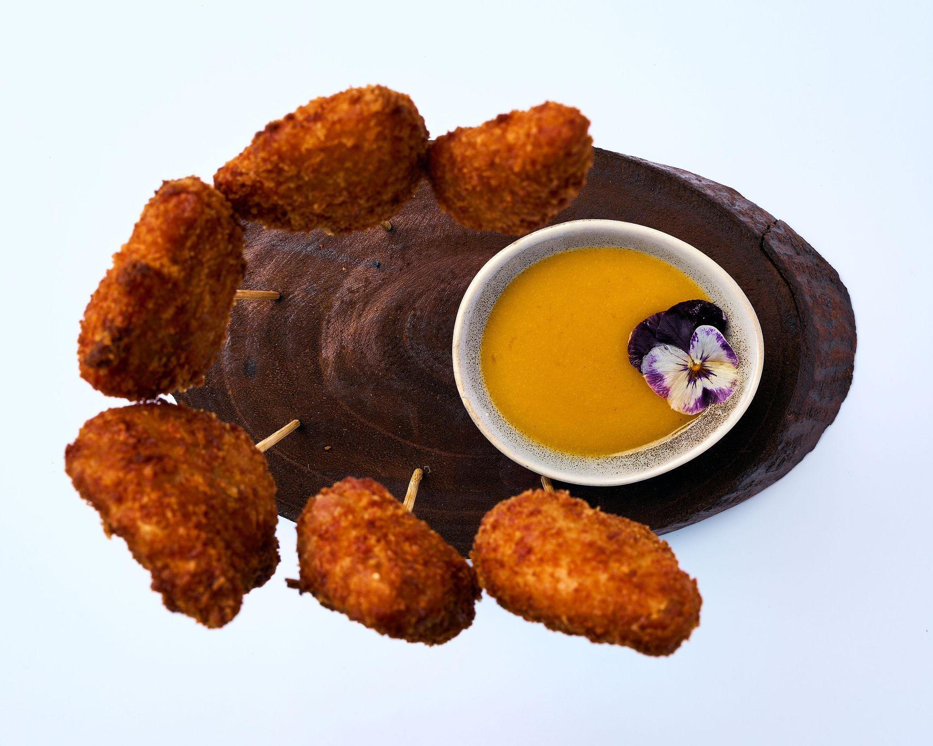 Una bandeja de madera llena de arroz y camarones sobre una mesa.