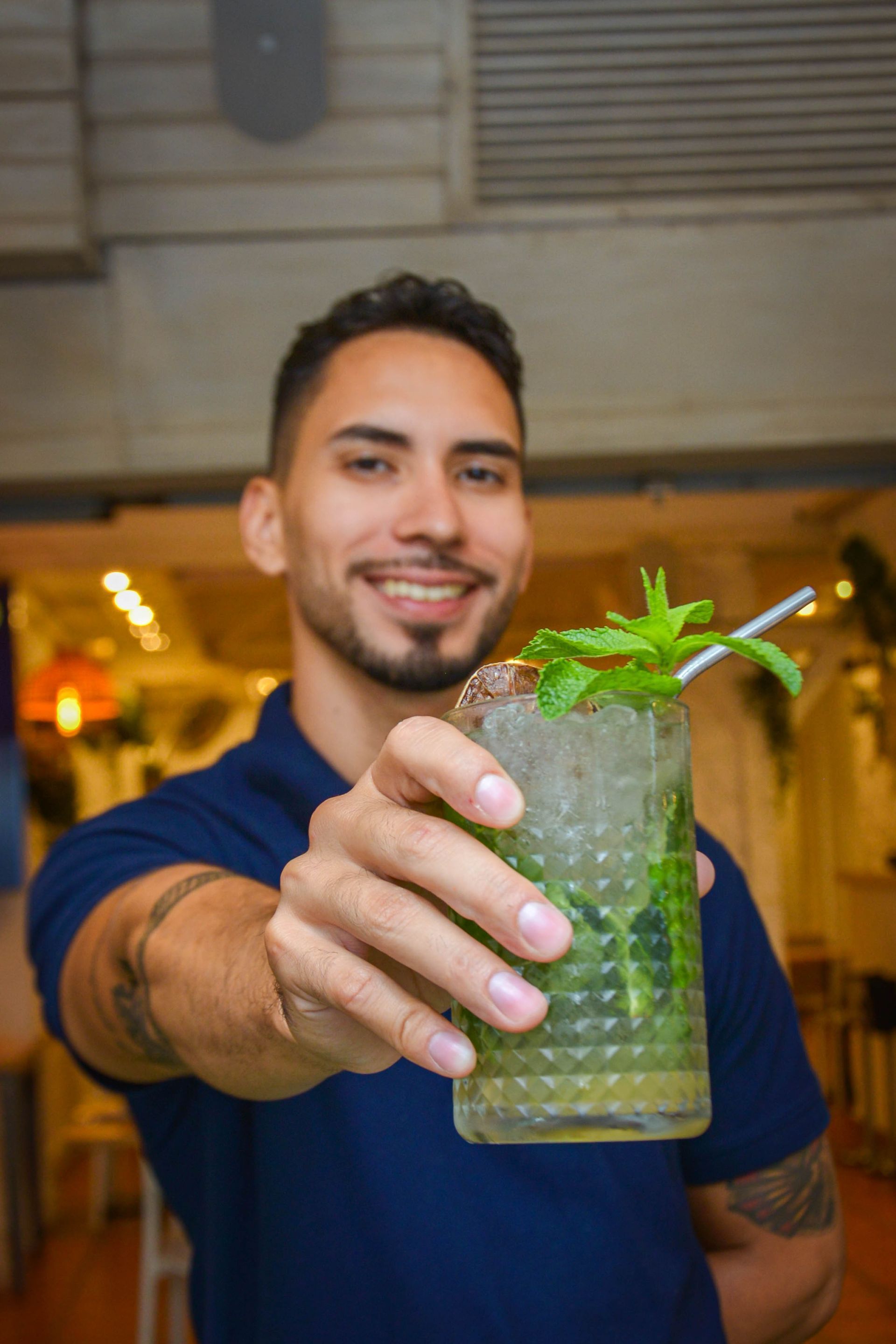 Un grupo de personas están sentadas en mesas afuera de un restaurante llamado Retratos.