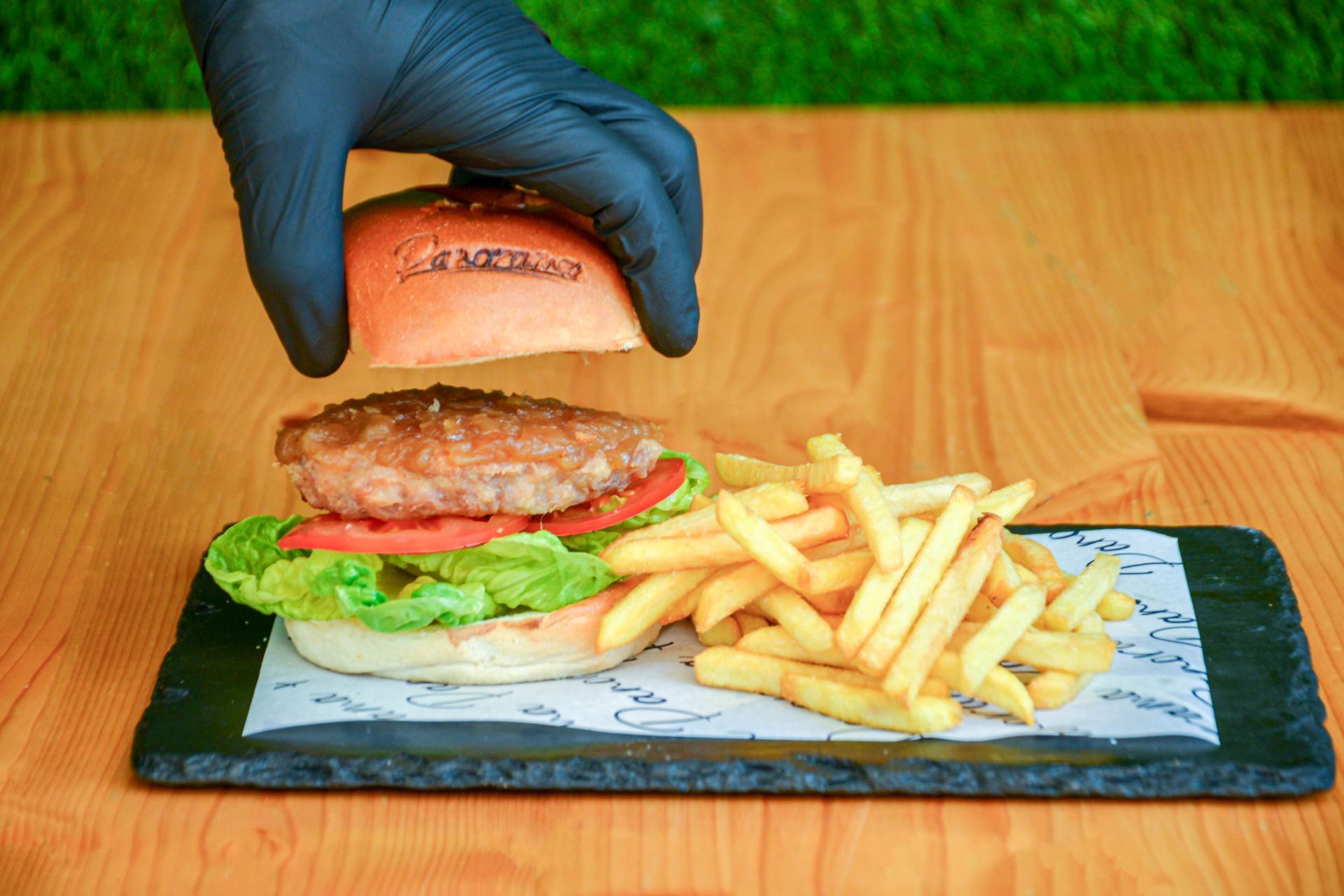 Una hamburguesa y papas fritas están en una tabla de cortar.