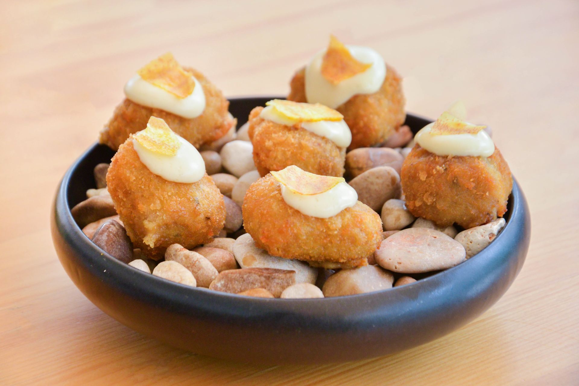 Un plato blanco cubierto con comida frita sobre una mesa.