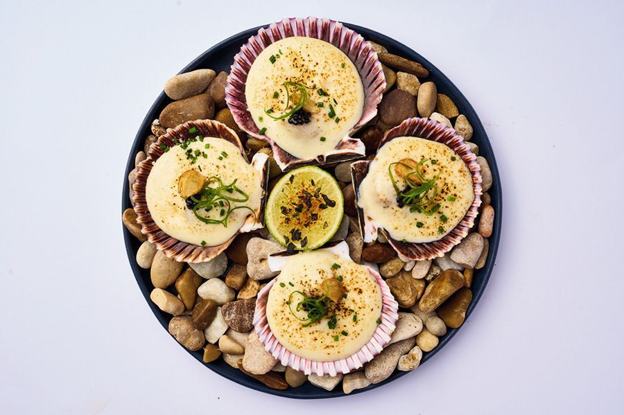 Un recipiente azul lleno de verduras sobre un fondo negro.