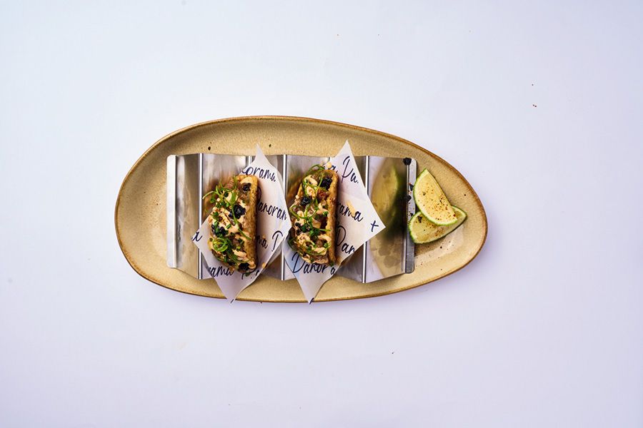 Una bandeja de madera llena de arroz y camarones sobre una mesa.