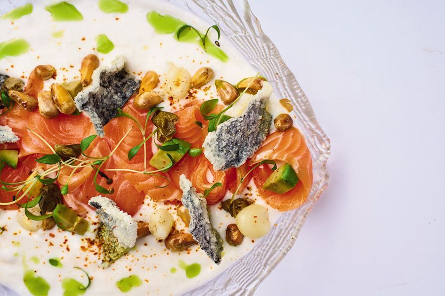 Una bandeja de madera llena de arroz y camarones sobre una mesa.