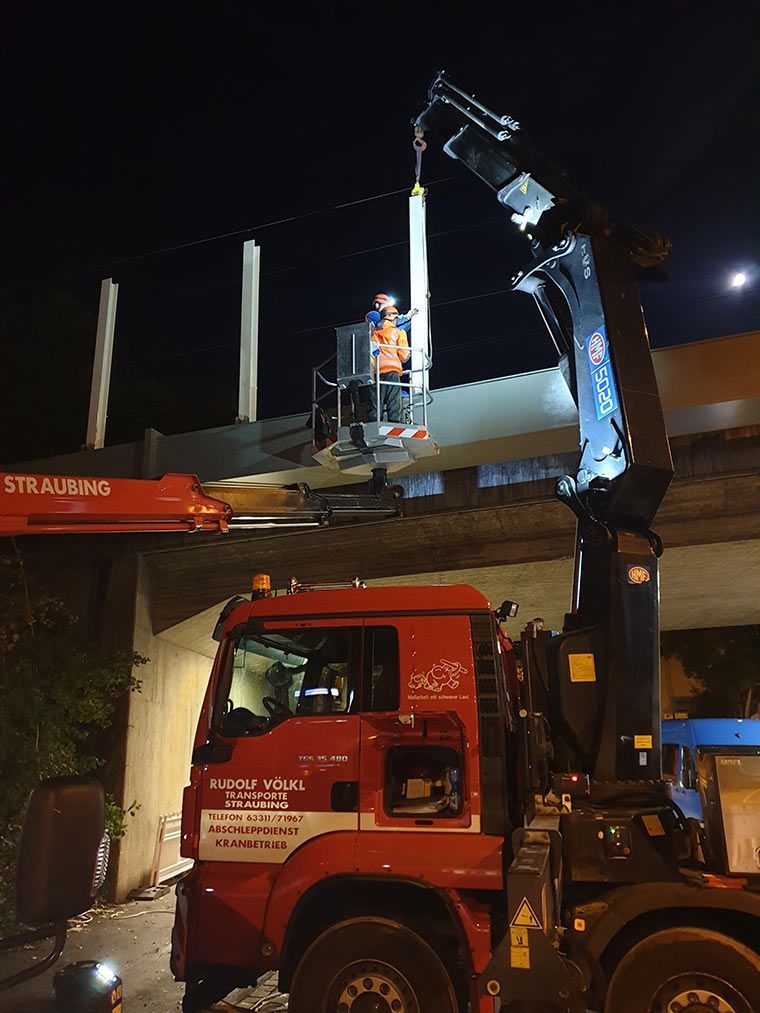 Lärmschutz wird von Kran Völkl an einer Brücke angebracht