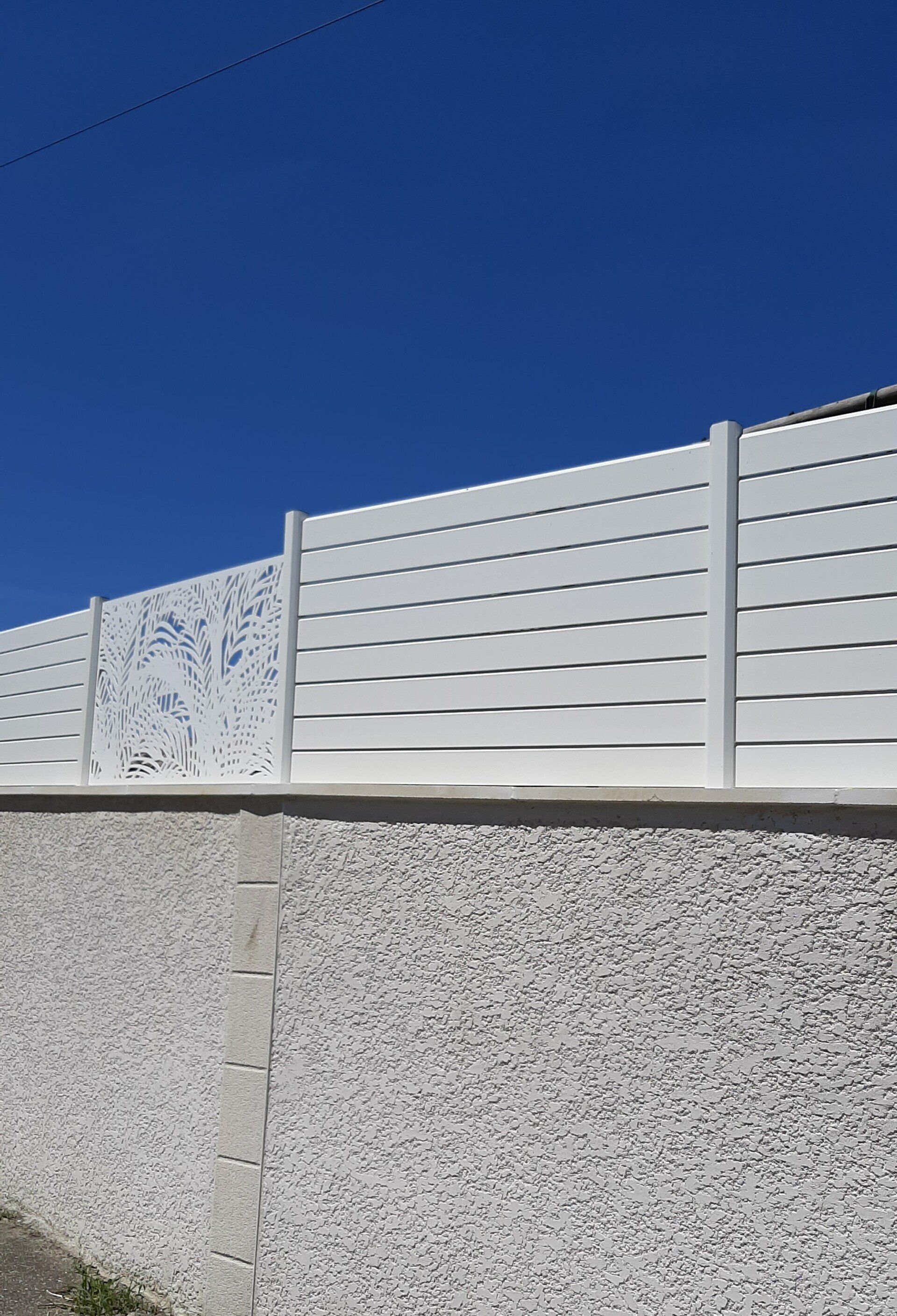 Clôture blanche posée sur un muret