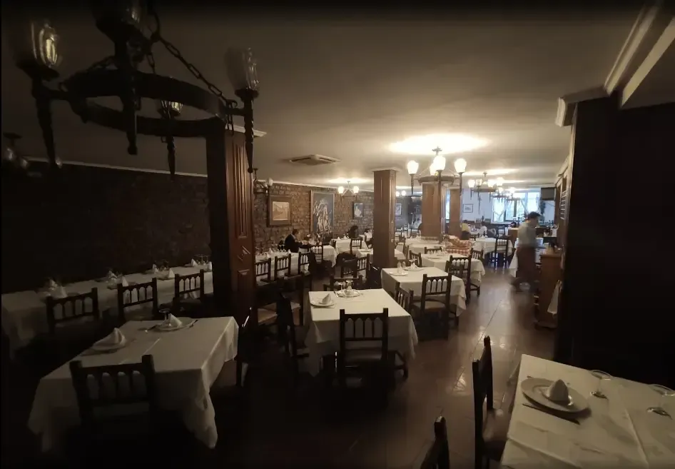 Interior de restaurante con mesas preparadas para cenar.