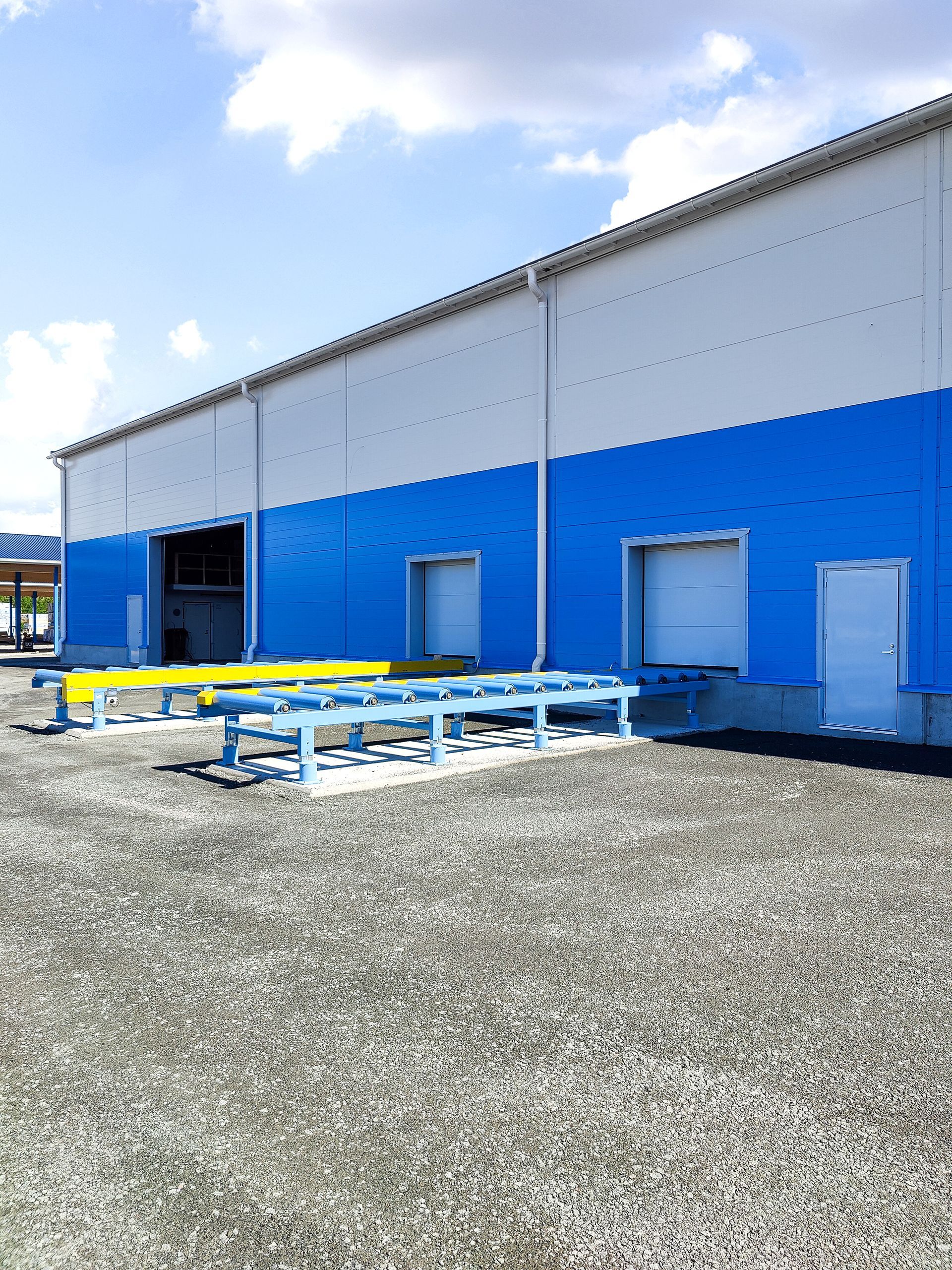 Sinivalkoinen rakennus, jonka edessä on paljon penkkejä