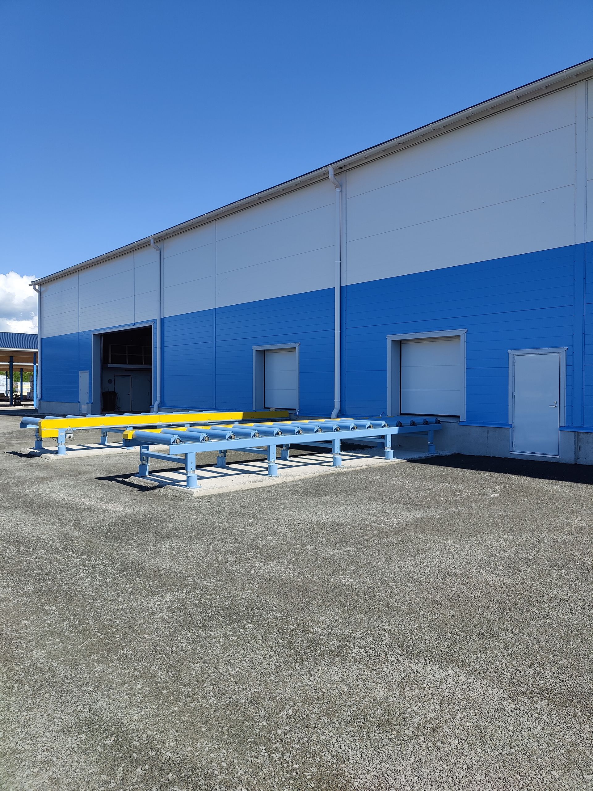 Sinivalkoinen rakennus, jonka edessä on keltaisia ​​penkkejä