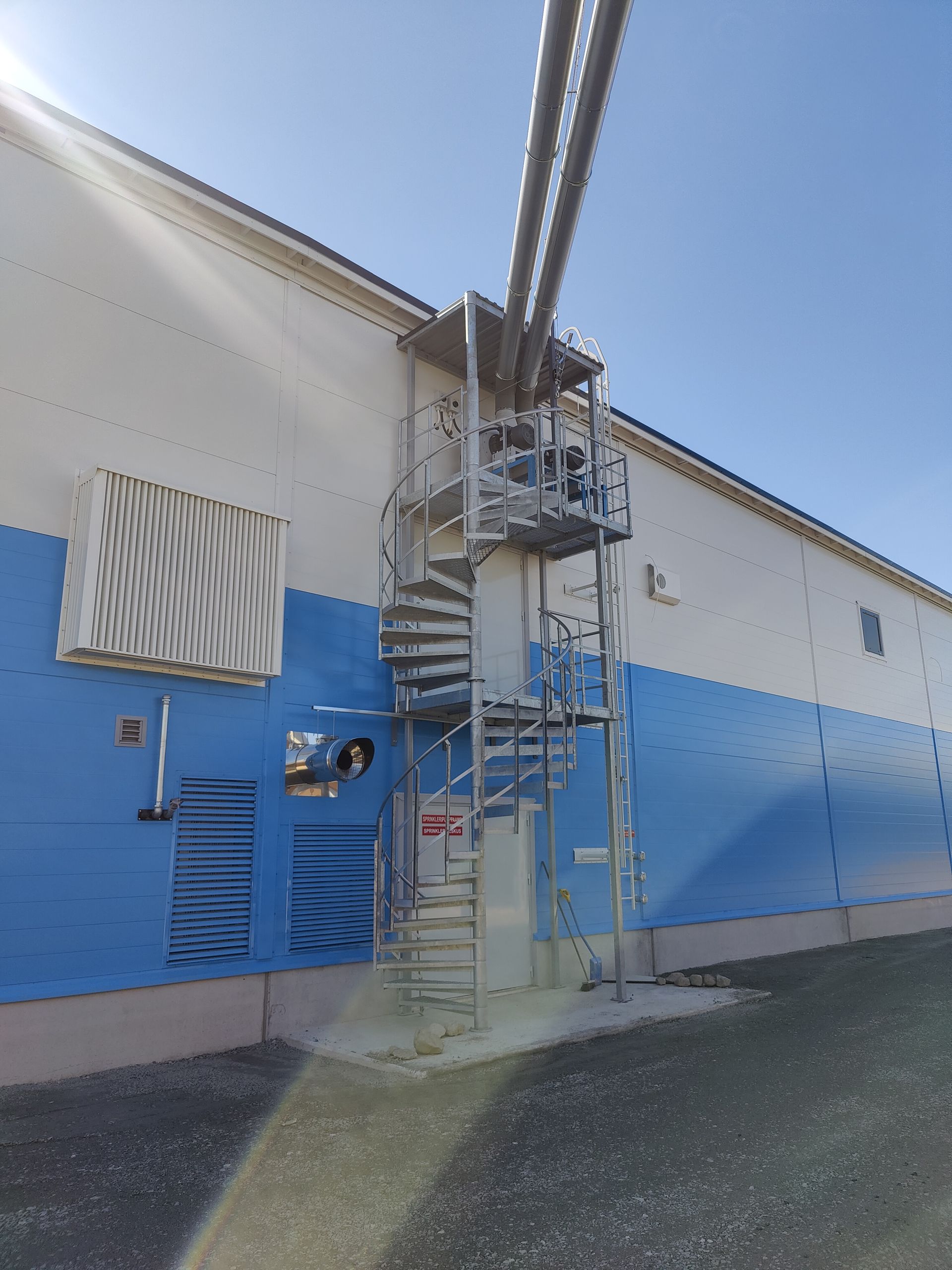 Sinivalkoinen rakennus, jonka sivulla on kierreportaat