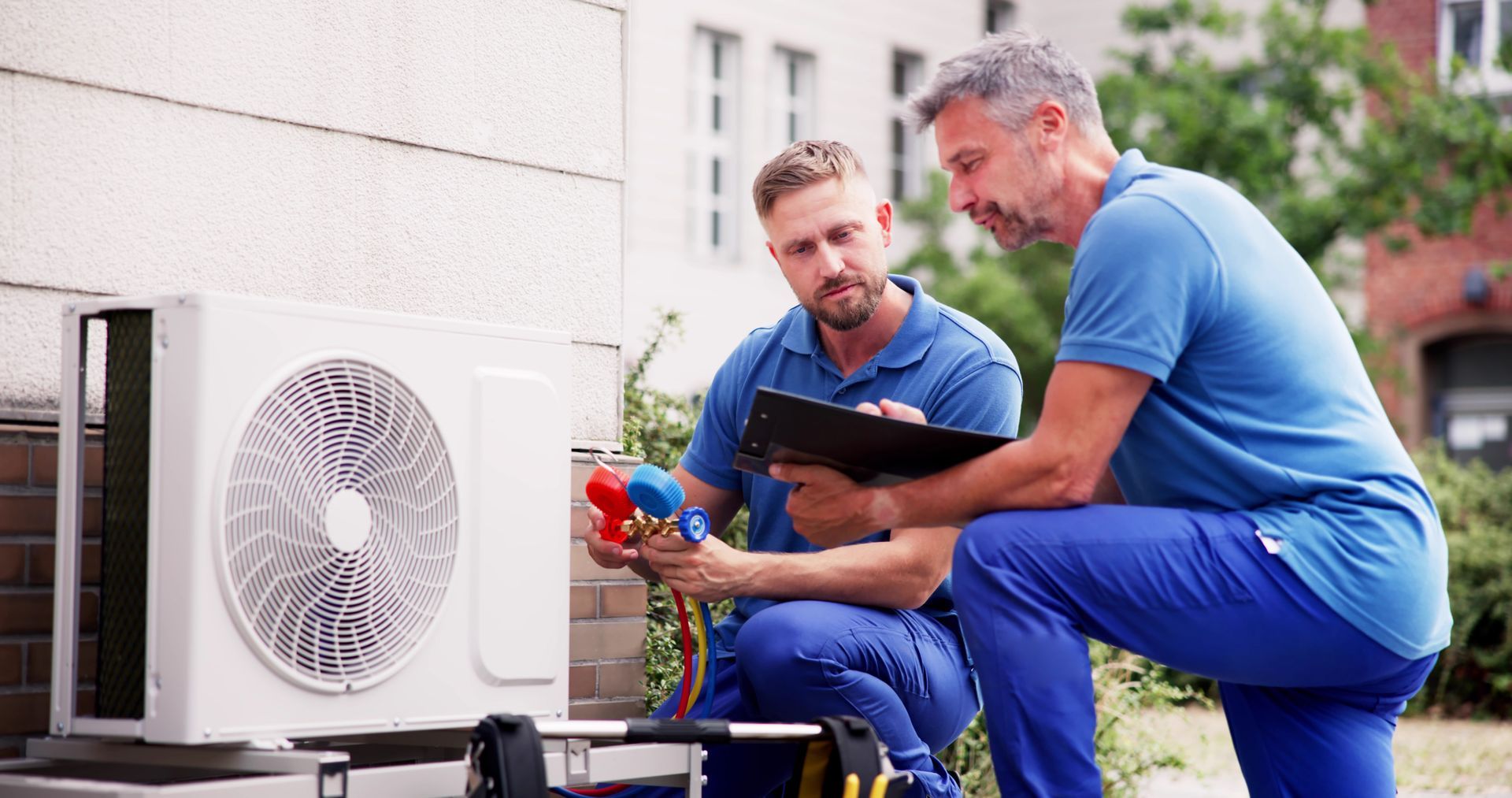 2 techniciens autour d'une pompe à chaleur
