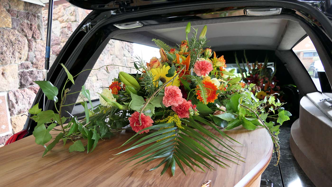 bouquet de fleurs sur un cercueil dans un corbillard