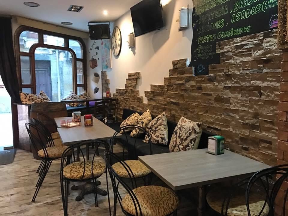 Un restaurante con mesas y sillas y una pared de ladrillos.