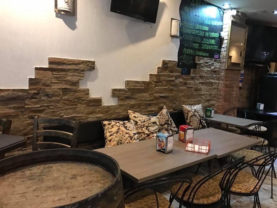 Un restaurante con mesas y sillas y un televisor en la pared.