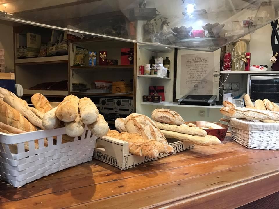 Un montón de pan está sobre una mesa de madera en una panadería.