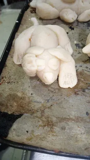 Una bandeja de pan con forma de cerdo está sobre una mesa.