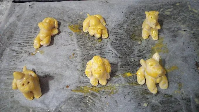 Un montón de animales hechos de masa están sentados en una mesa.