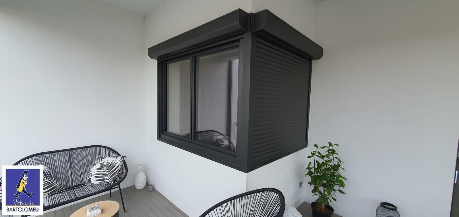 Fenêtres d'angles en aluminium noires vues de l'extérieur avec volets roulants