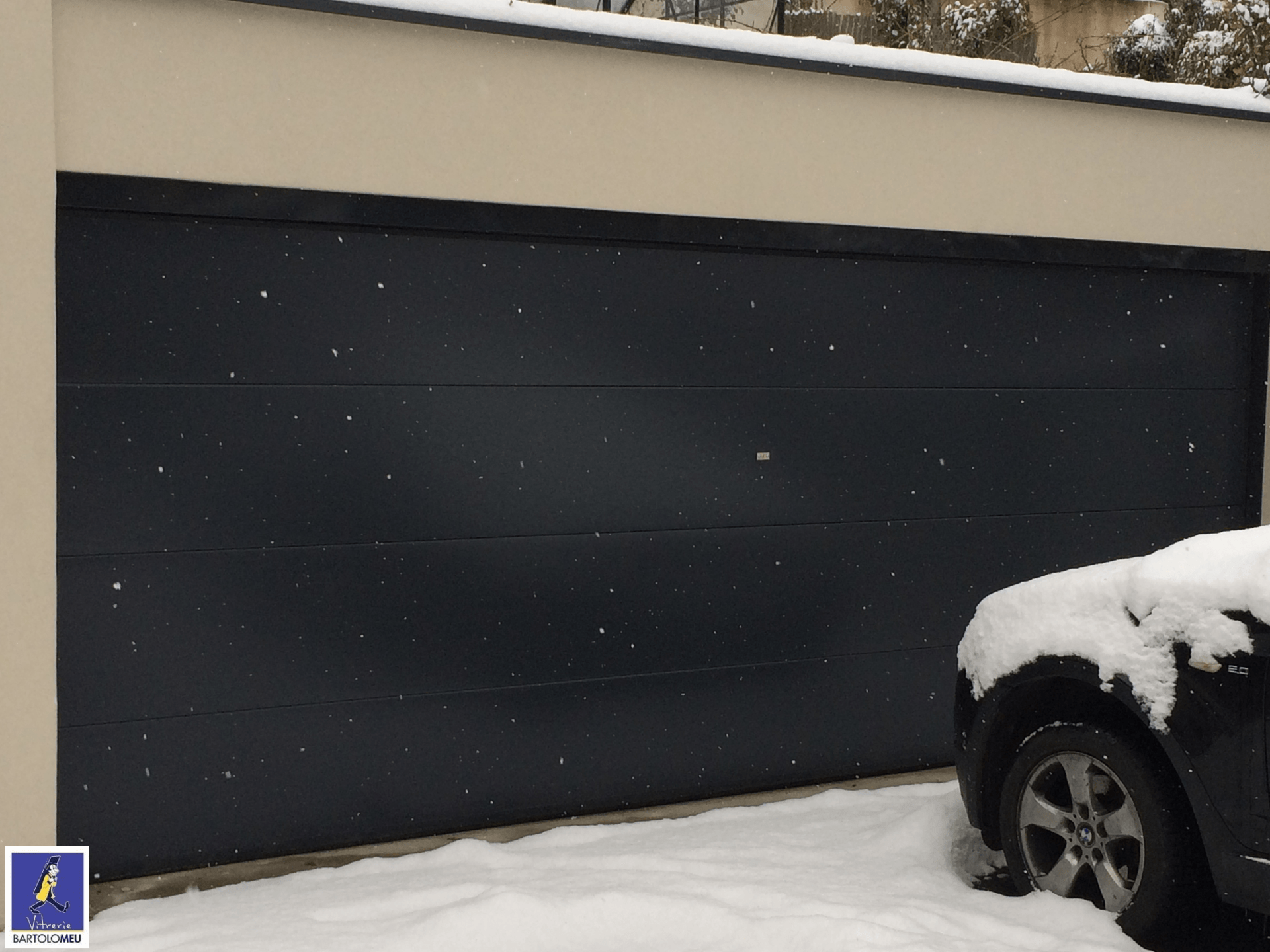 Porte de garage noire et neige
