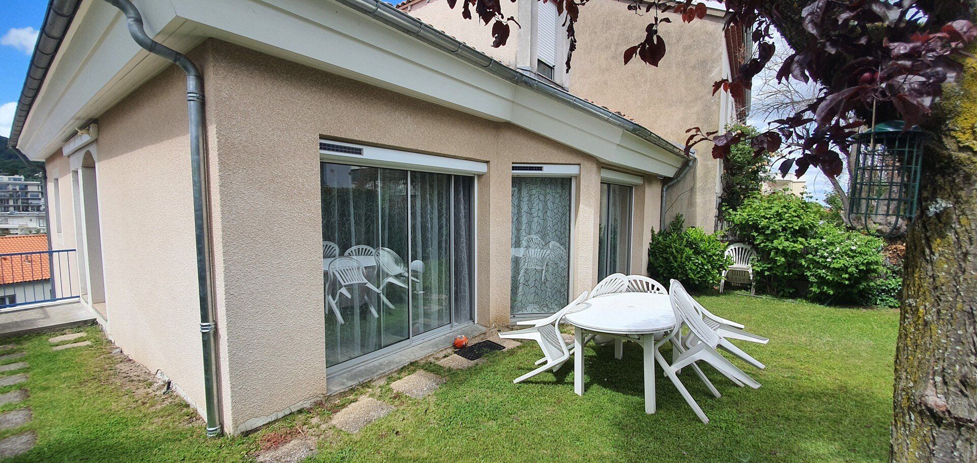 Extérieur de maison avec herbes et baies vitrées