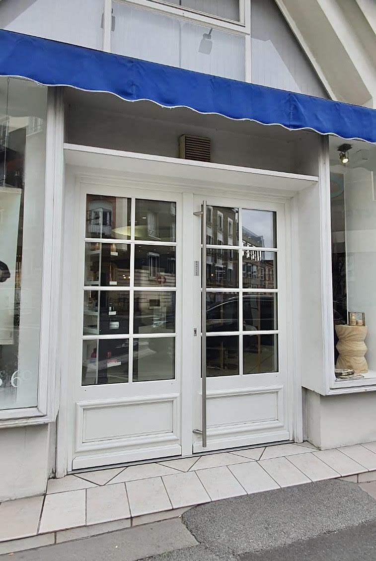 Porte d'entrée de magasin vitrée et blanche vue de l'extérieur