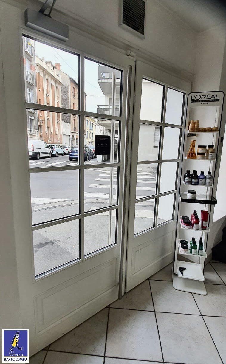 Porte d'entrée de magasin vitrée et blanche vue de l'intérieur