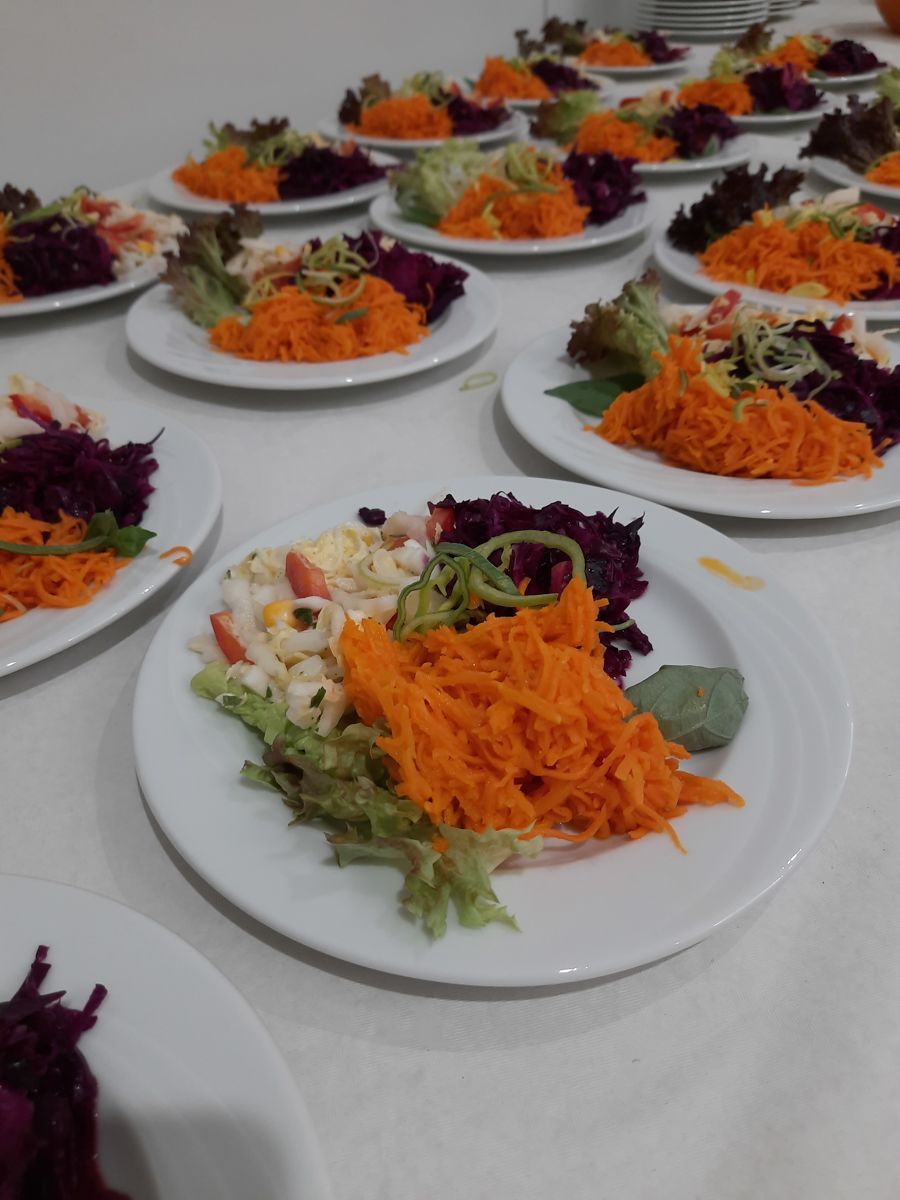 eine Reihe von Tellern mit verschiedenen Salatsorten auf einem Tisch