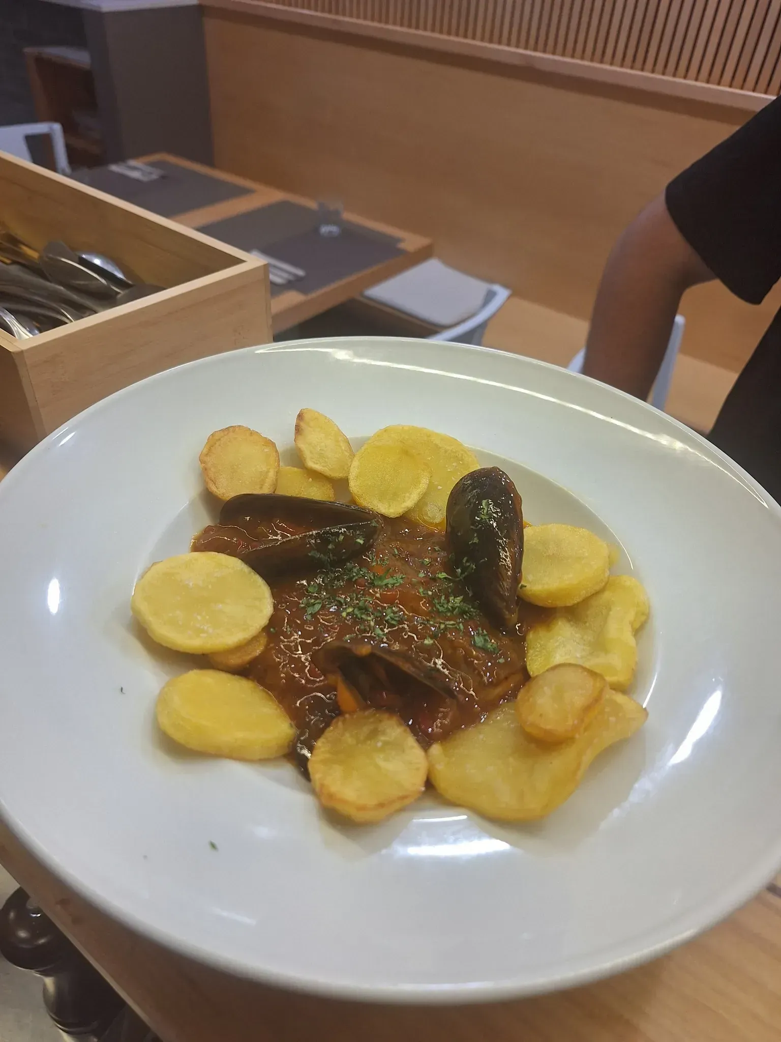 Plato de comida con patatas y carne en salsa.