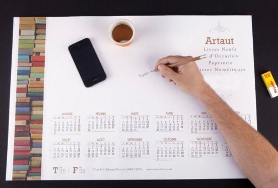 Personne qui écrit sur un grand calendrier papier