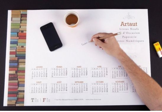 Personne qui écrit sur une grand calendrier papier