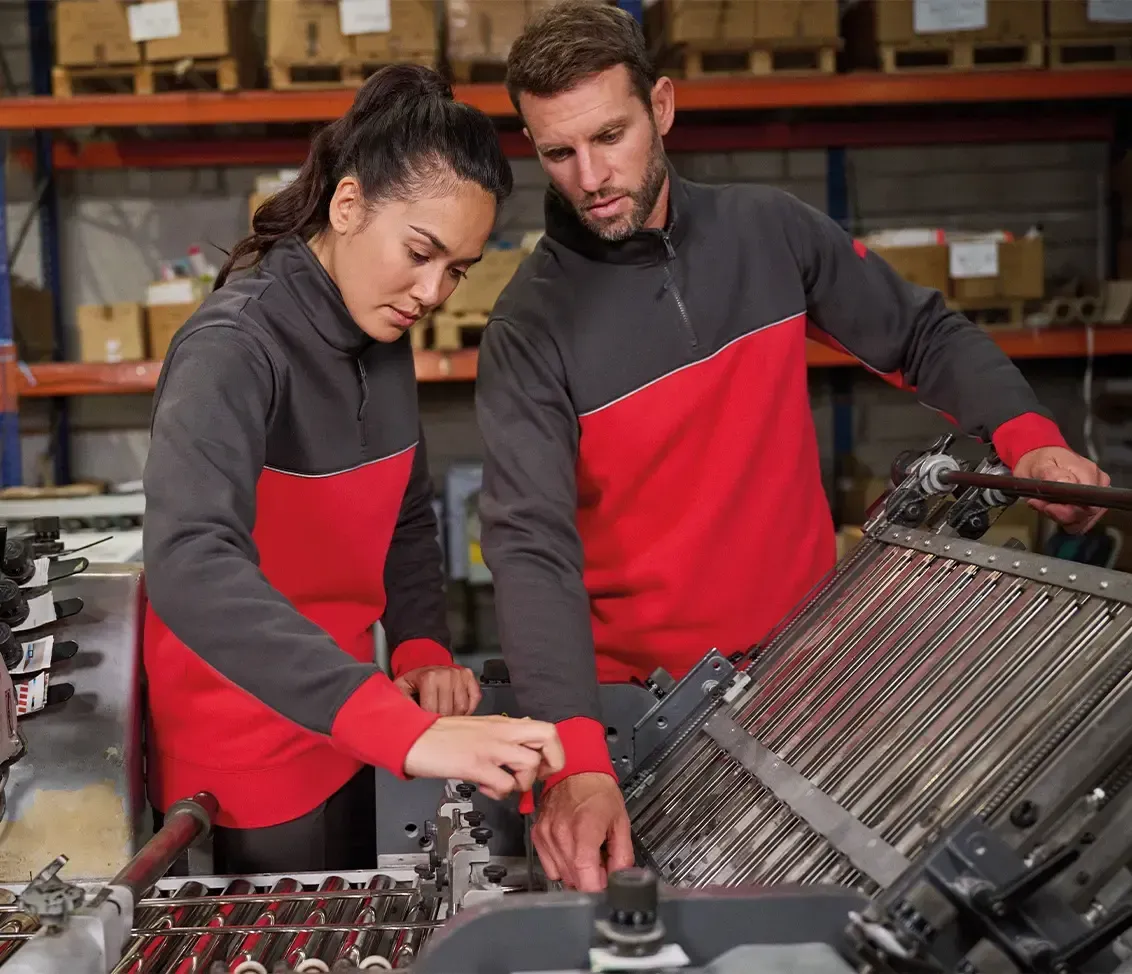 2 personnes qui réparent une machine
