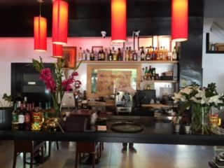 Un restaurante con lámparas rojas colgando del techo.