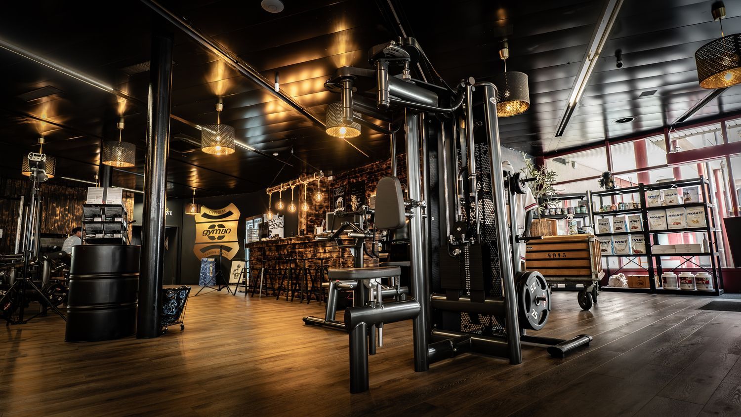 Menschen, die in einem Fitnessstudio Ausfallschritte mit Kurzhanteln machen und sich dabei auf das Krafttraining der unteren Körperhälfte konzentrieren.
